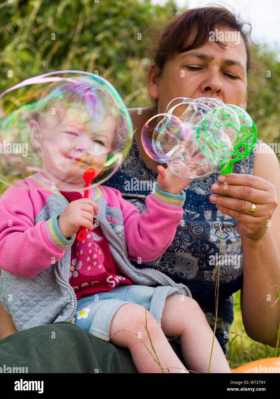 Tout-petit et grand-mère jouant avec les bulles, UK Banque D'Images