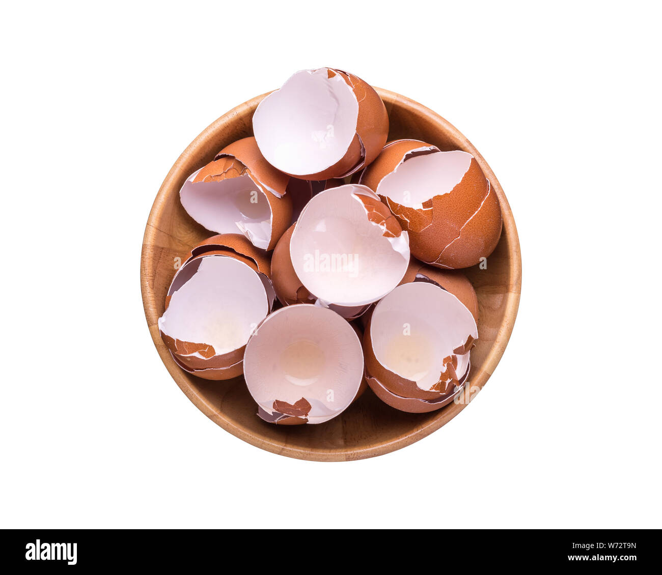 Pile de coquille de l'oeuf dans un bol en bois. Vue d'en haut et isolé sur fond blanc Banque D'Images