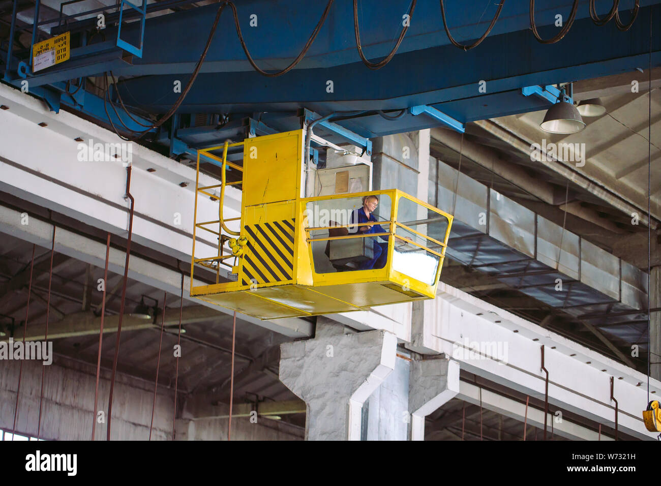 La jeune fille travaillant dans la cabine d'une grue. L'industrie lourde, l'usine de métal. Banque D'Images