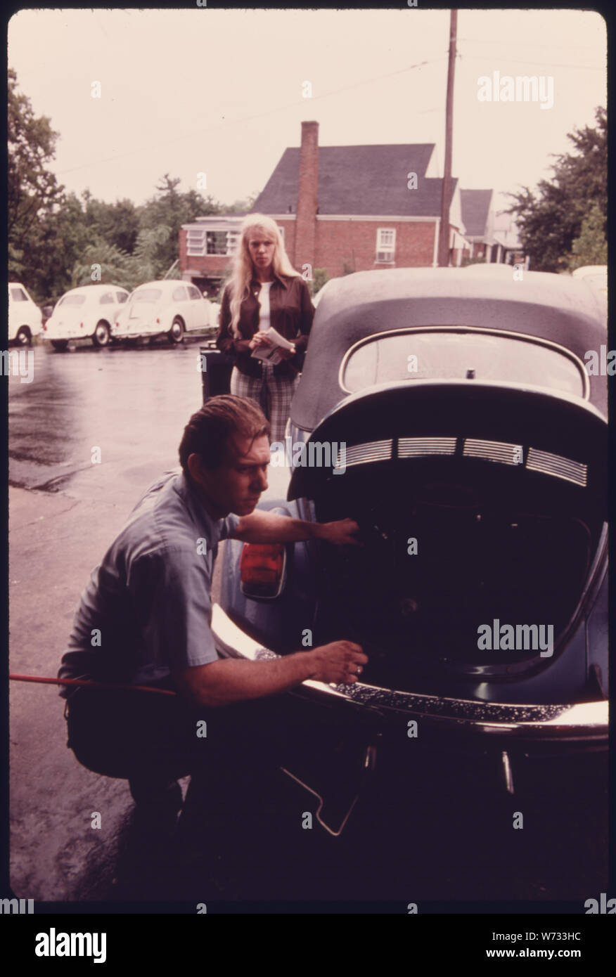 Mécanicien de STATION-SERVICE RÈGLE LE RÉGIME MOTEUR POUR UNE JEUNE FEMME DONT LE VÉHICULE avait échoué à l'ESSAI D'ÉMISSIONS À UN POSTE D'INSPECTION DES GAZ D'ÉCHAPPEMENT DES AUTOMOBILES AU CENTRE-VILLE DE Cincinnati, Ohio. Bien que LA STATION N'A PAS LE MÊME TYPE D'ANALYSEUR D'ÉCHAPPEMENT QUE LA VILLE UTILISE, IL SERA EN MESURE DE RÉGLER LE CARBURATEUR POUR PASSER L'INSPECTION. Les tests d'émissions A ÉTÉ EN VIGUEUR DEPUIS JANVIER 1975 POUR LE MONOXYDE DE CARBONE ET D'HYDROCARBURES. (Voir les photos # 15471 à 78) Banque D'Images