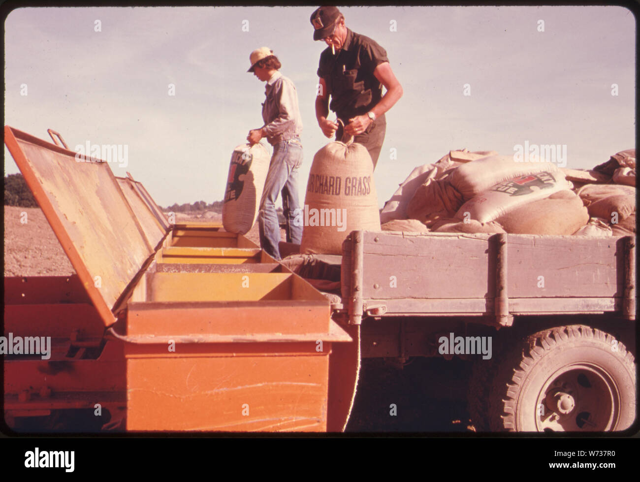 Le mélilot ET ORCHARD GRASS sont versées dans un bulldozer-TIRÉ SEEDER QUI VA SE PROPAGER IL 450 LIVRES À L'ACRE LA TERRE EST RESEMÉS APRÈS L'EXPLOITATION DE MINES DE CHARBON DANS LE SUD-EST entreprises en Ohio. À PARTIR DE LA ROUTE # 800 PRÈS DE MORRISTOWN Banque D'Images