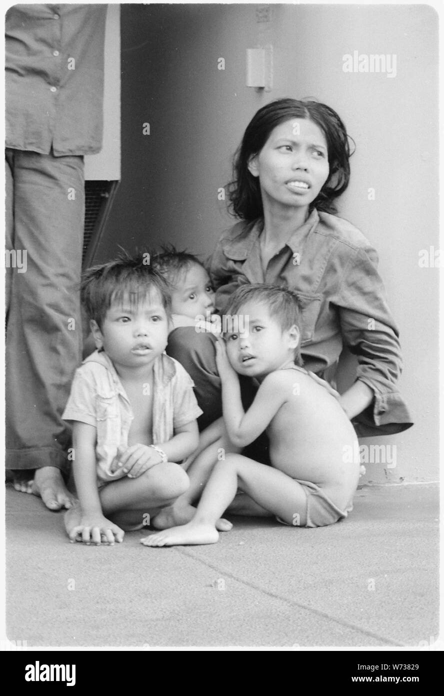 Mer de Chine du Sud....une réfugiée prend soin de trois petits enfants sur la reconstitution oiler USS Wabash, AR-5. Vingt-huit personnes ont été choisis le bateau de leur bateau en bois par un graisseur de la baleinière. Banque D'Images