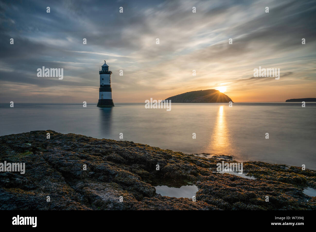 Été magnifique lever de soleil sur l'île de macareux (Ynys Seiriol) et Penmon Point (Du) * 1963 : ouverture intégrale de Phare, Anglesey, Pays de Galles, Royaume-Uni Banque D'Images