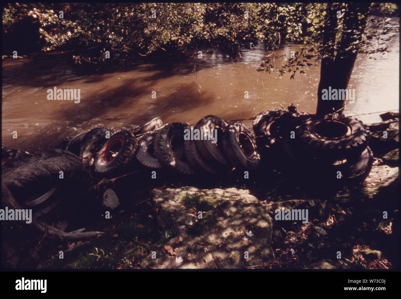 Pneus placés à détourner l'EAU DU HAUT DE LA BERGE DE LA RIVIÈRE CUYAHOGA QUI PASSE PRÈS DE RIVERVIEW ROAD, AU SUD DE LA ROUTE DE L'IRA près de Akron, Ohio. Ils ont été placés là PAR LE COMTÉ DE SUMMIT Bureau d'ingénieurs. La RIVIÈRE ET LA VALLÉE FONT PARTIE DES 30 000 acres Cuyahoga Valley National Recreation Area QUI EST ENTRÉ EN ACTIVITÉ EN DÉCEMBRE 1975. La zone comprend le dernier grand terrain non aménagé entre Akron et Cleveland. Les fonctionnaires SONT MAINTENANT EN ATTENTE POUR LE CONGRÈS D'ARGENT POUR ACHETER DES TERRAINS APPROPRIÉS Banque D'Images