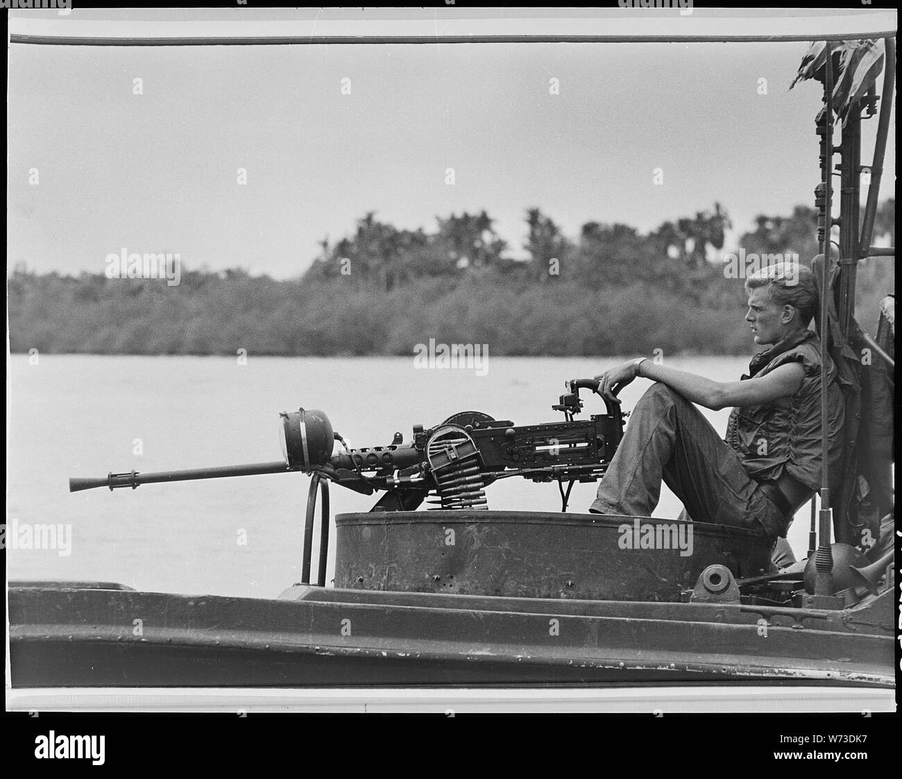 Vietnam .... UNE U.S.Navy river le bateau de patrouille (PBR) maintient la vigilance à l'équipage de calibre 50 fusil pendant la journée du bateau patrouille sur la rivière Cong aller. Banque D'Images