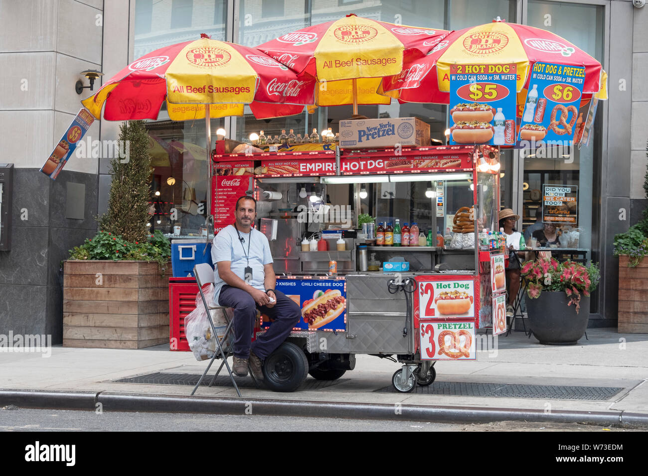 Un vendeur de hot dog vente alimentaire, bretzels, sodas, etc. juste à côté de la Cinquième Avenue à Manhattan, Midtown, USA. Banque D'Images