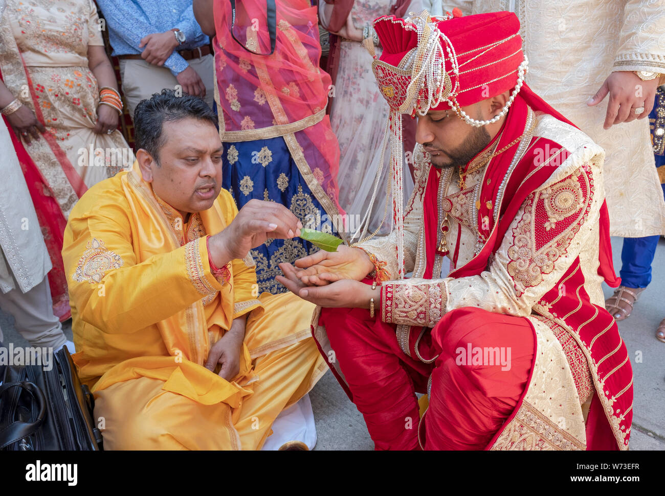 Lors d'un mariage hindou traditionnel le prêtre et le marié Rituels effectuer en dehors du temple avant la cérémonie. En Ozone Park, Queens, New York. Banque D'Images