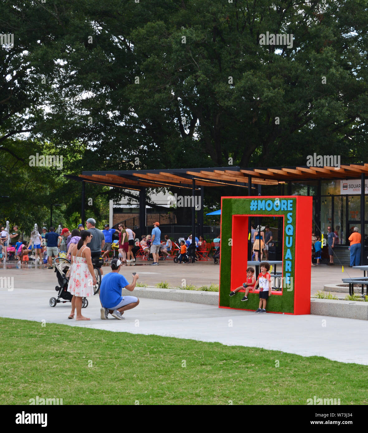 Les visiteurs posent pour des photos à l'inscription en Moore Square. Le centre-ville de Raleigh park a récemment subi une rénovation et ré-ouvert au public en 2019. Banque D'Images