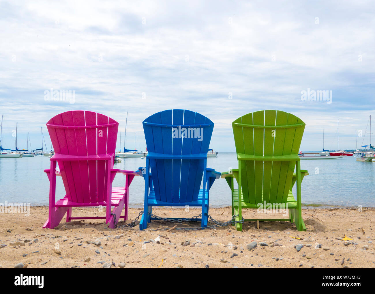 Muskoka Cottage multicolores chaises de plage sur le sable en regardant le port Banque D'Images