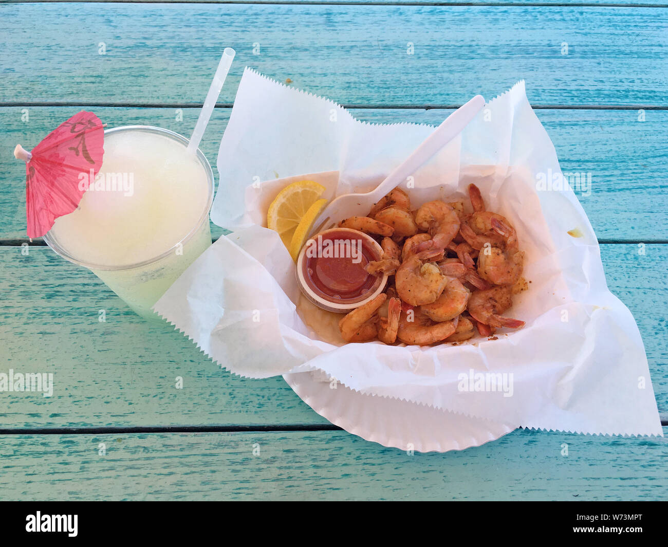 Peler N' manger des crevettes bouillies avec assaisonnement cajun et une bonne limonade congelé à boire Banque D'Images