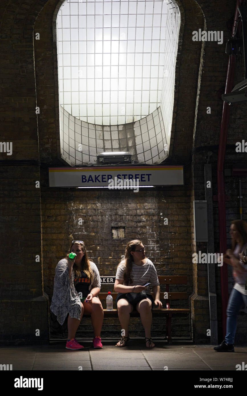 La station de métro Baker Street, un couple assis sous l'arbre de ventilation d'origine, London, England, UK Banque D'Images