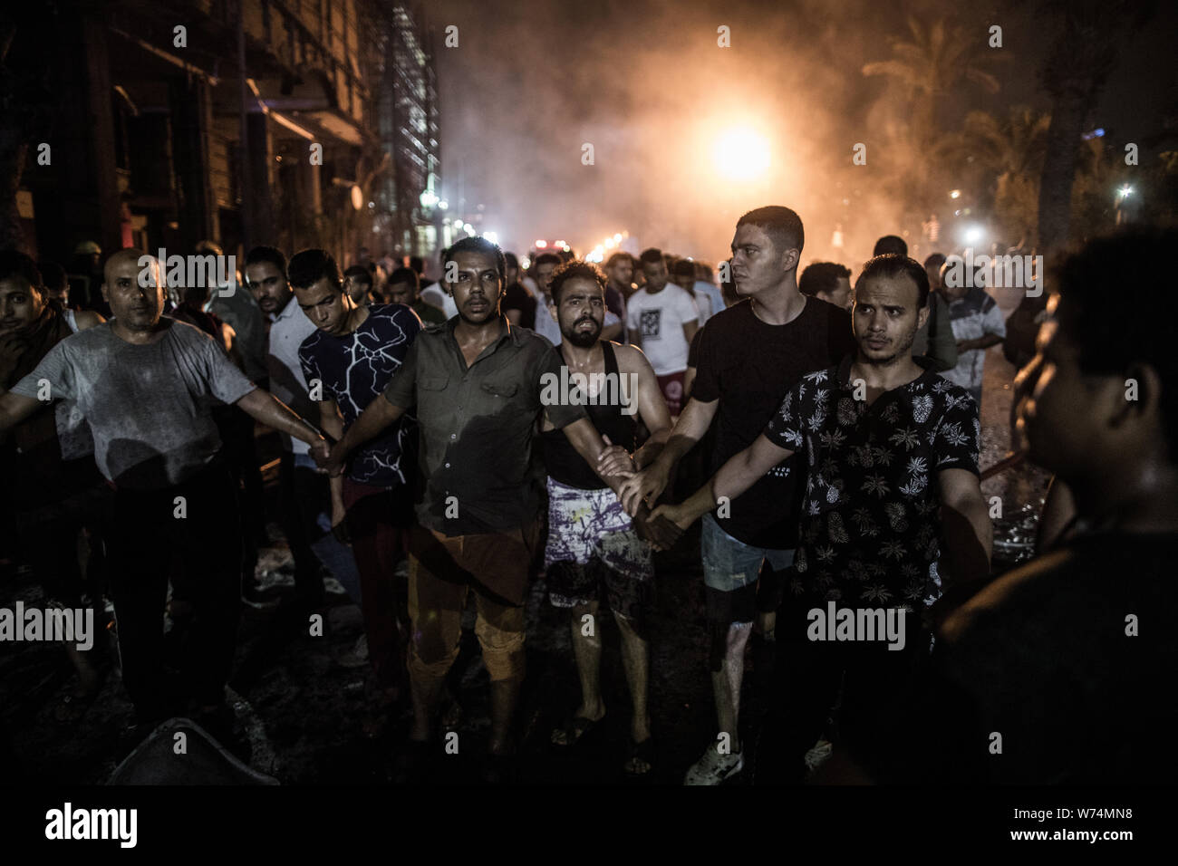 Le Caire, Égypte. Le 05 août, 2019. Les gens entourent un corps mort après une explosion en face de l'Institut National du Cancer. Selon le ministère de la santé, au moins 17 personnes sont mortes et 26 blessées. Credit : Oliver Weiken/dpa/Alamy Live News Banque D'Images