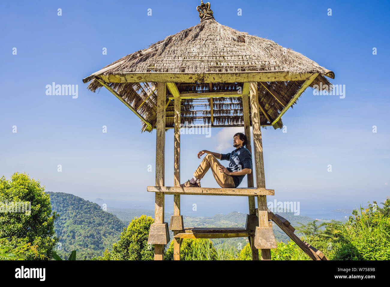 Jeune homme dans le gazebo balinais traditionnels. L'île de Bali Photo  Stock - Alamy