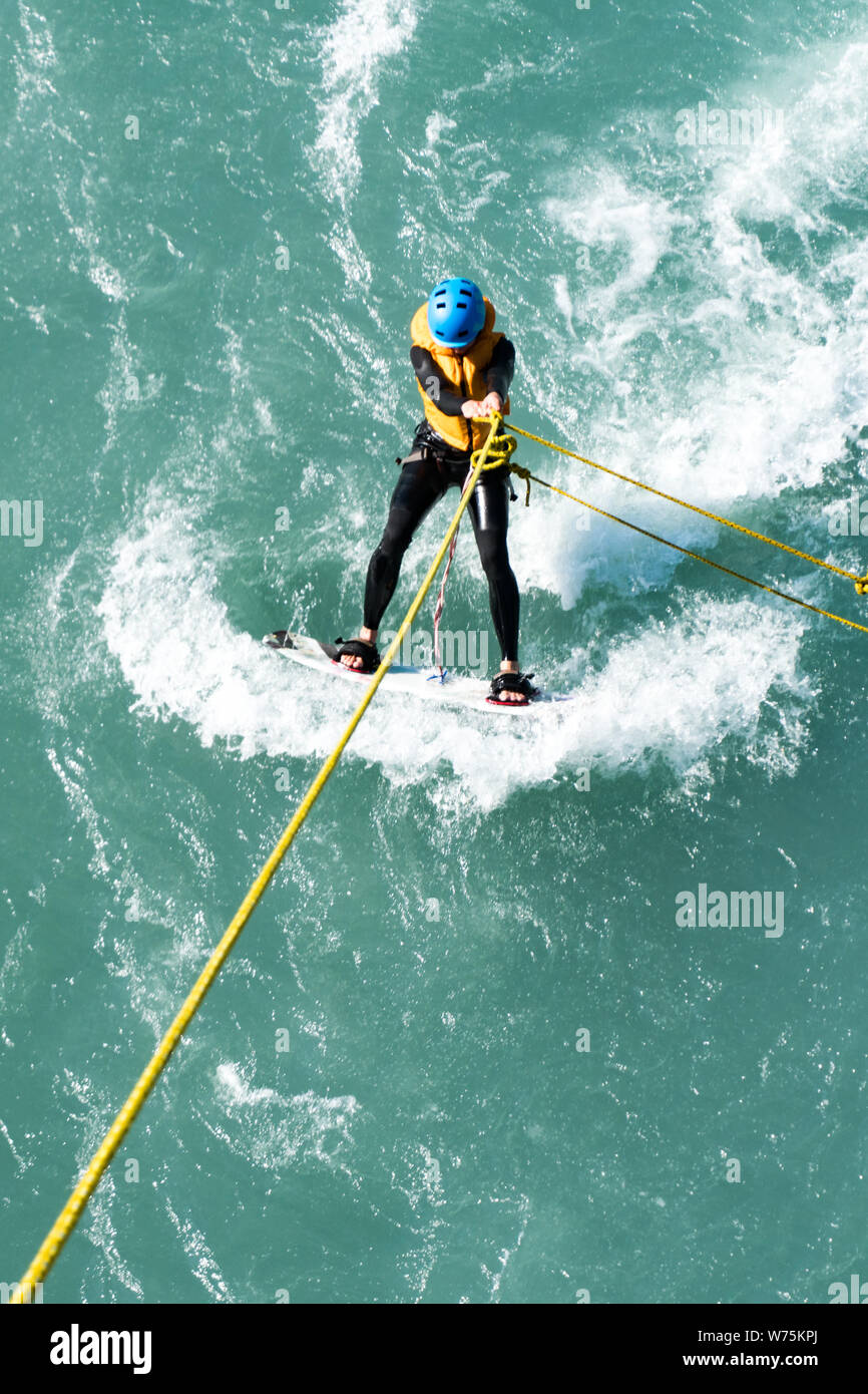 Maienfeld, GR / Suisse - 4. Août 2019 : planche de surf sur une rivière avec une corde attachée à un pont Banque D'Images