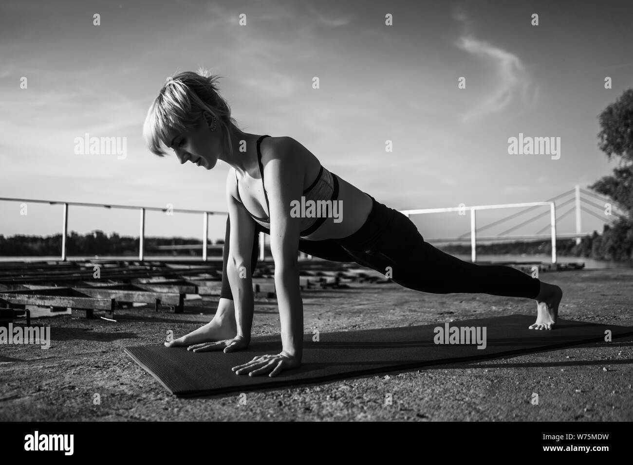 Femme l'exercice de pilates sur journée ensoleillée. Fente basse stretch yoga exercice. Banque D'Images