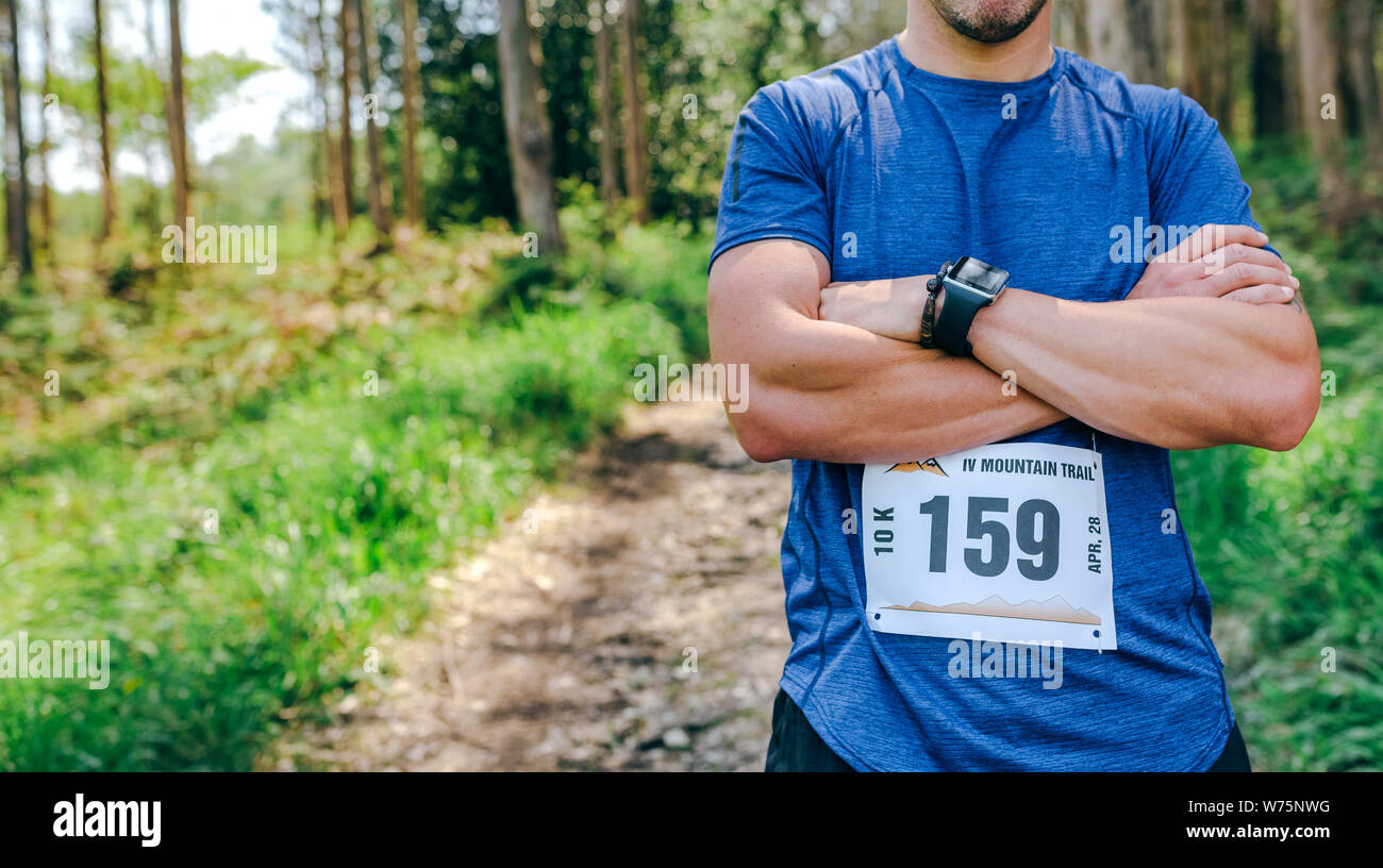 Athlète masculin trail posant avec numéro de course Banque D'Images