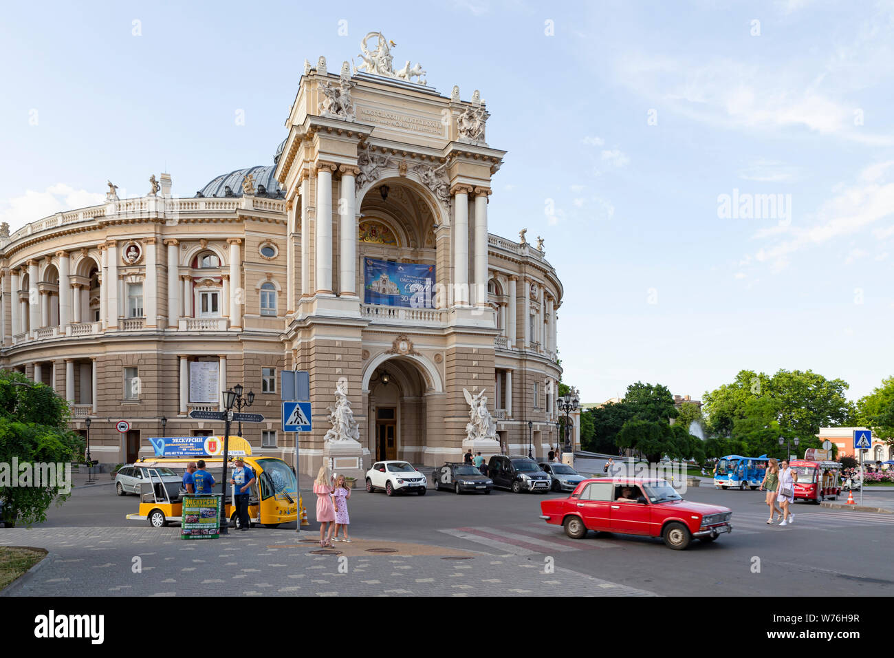 L'Ukraine, Odessa, Lanzheronivska street, 11 juin 2019. Vue de face de l'opéra et théâtre de ballet avec une voiture rouge et visite touristique buse Banque D'Images