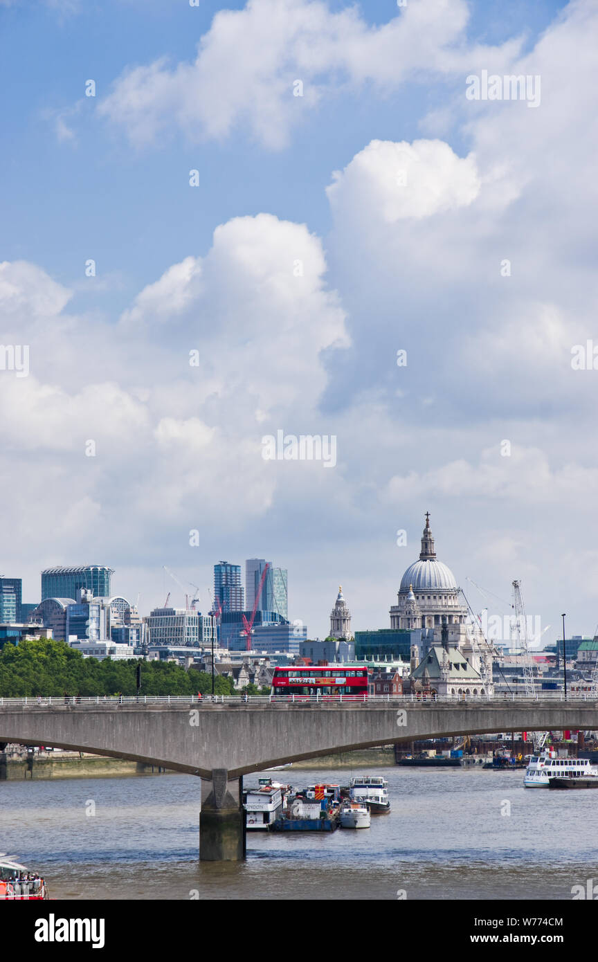 Un bus rouge traverse Londres Waterloo Bridge sur la Tamise, avec la cathédrale St Paul visible sur l'horizon. Banque D'Images