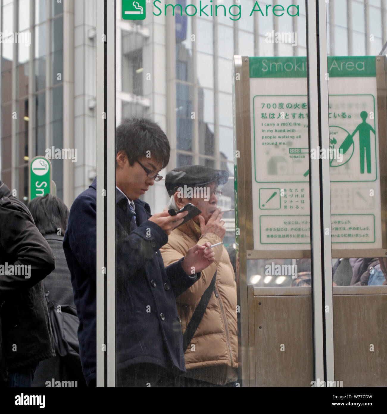 Tokyo, Japon - 15 mai 2019 : Les fumeurs debout dans un espace fumeurs dans la ville. Banque D'Images