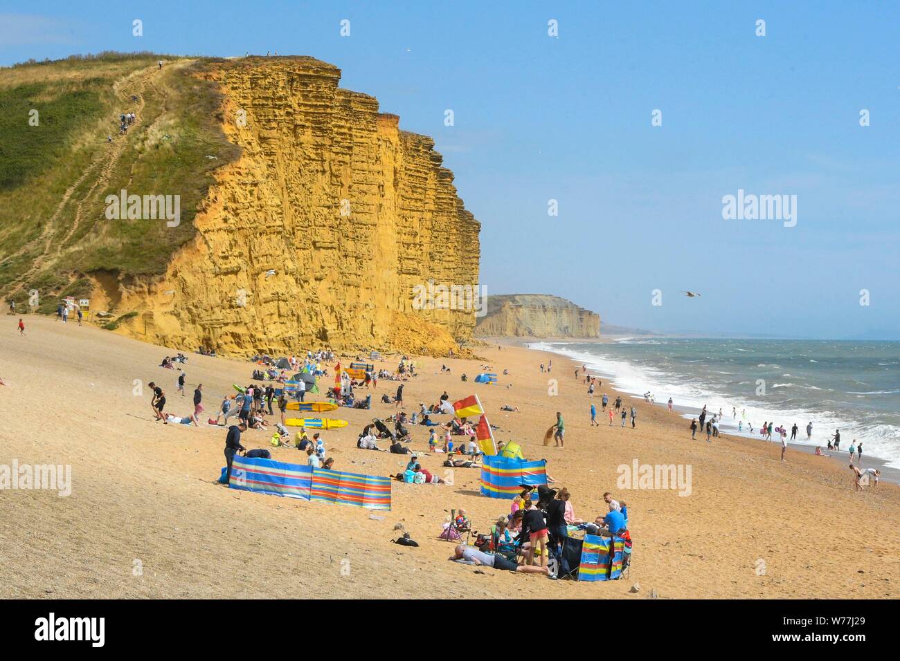 West Bay, Dorset, UK. 5 août 2019. Météo britannique. Vacanciers et baigneurs sur la plage à la station balnéaire de West Bay dans le Dorset par une chaude journée ensoleillée. Crédit photo : Graham Hunt/Alamy Live News Banque D'Images