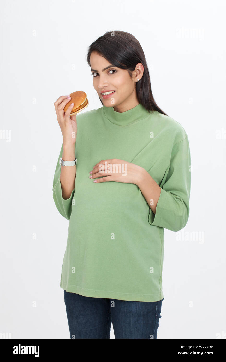Pregnant woman eating hamburger Banque D'Images