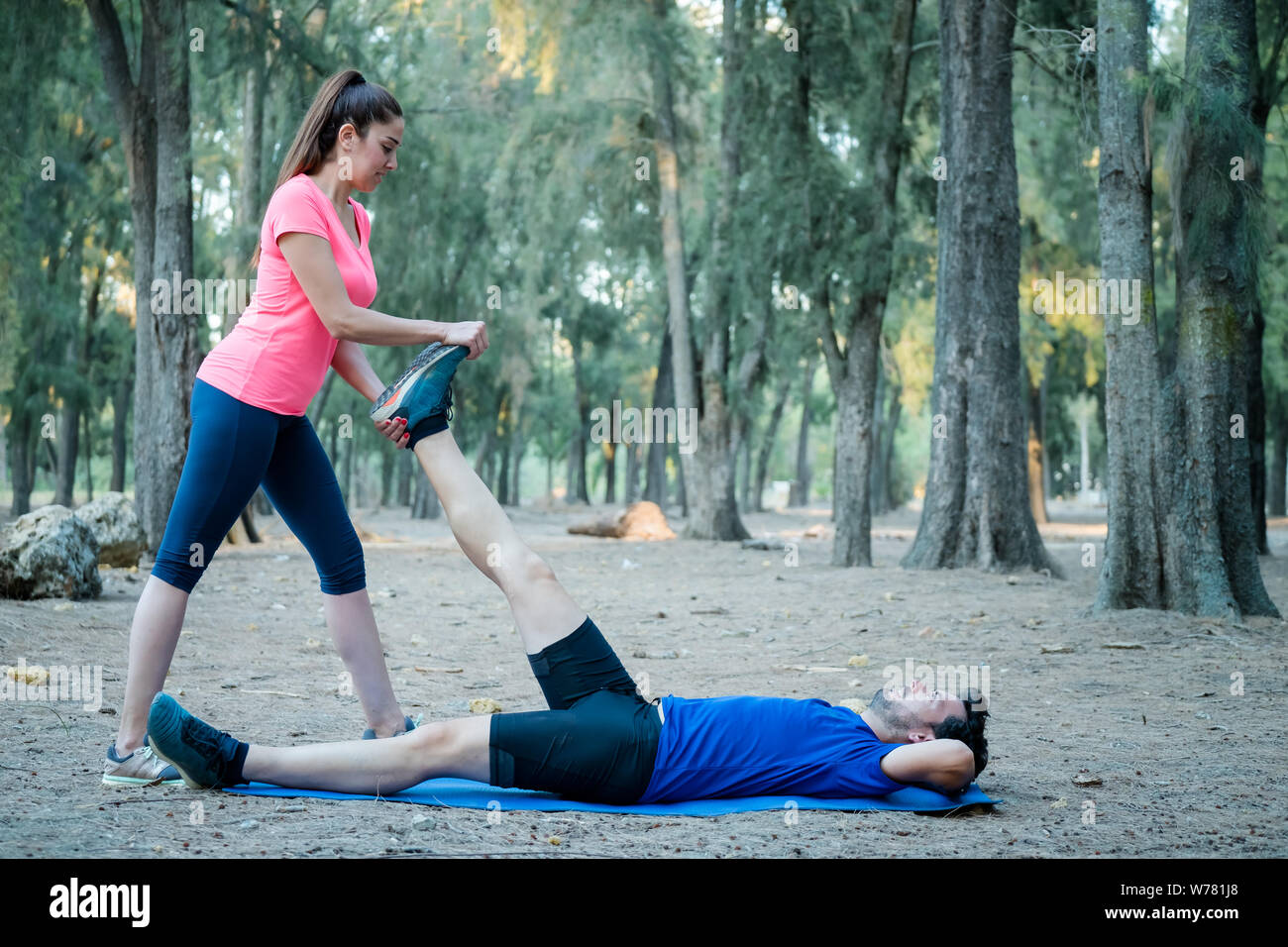 Couple faisant des exercices d'étirement dans un parc Banque D'Images