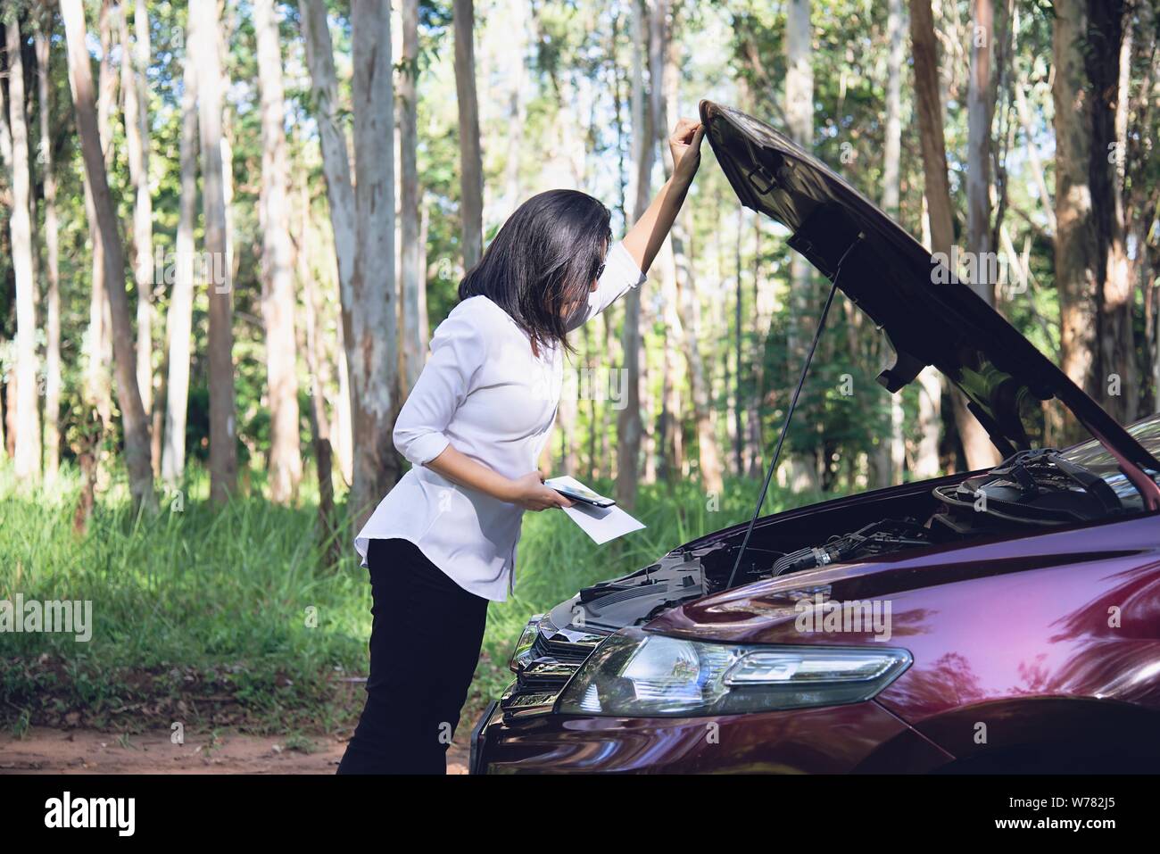 Femme Asiatique réparateur ou le personnel d'assurance demande de fixer un problème de moteur de voiture sur une route locale, - les personnes ayant des problème de voiture concept de transport Banque D'Images