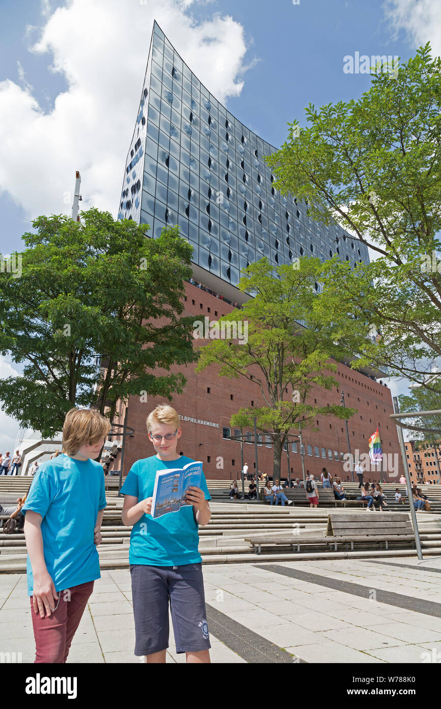 Les adolescents pendant l'étude d'une langue sur l'étude de leur voyage guide de la ville en face de la Philharmonie de l'Elbe, Hambourg, Allemagne Banque D'Images