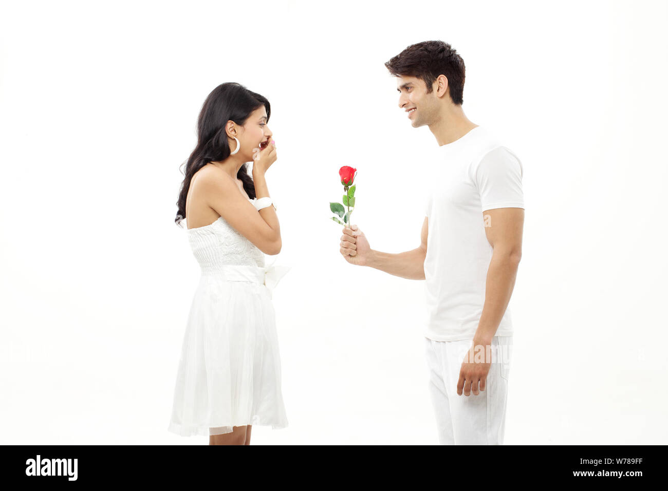 Homme offrant une rose à la femme et souriant Banque D'Images