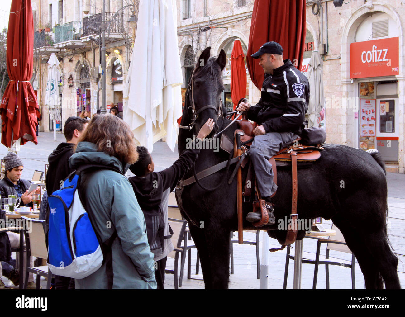 Un cheval belge dans la Police israélienne et un agent de police d'attirer l'attention des piétons à Jérusalem. Banque D'Images