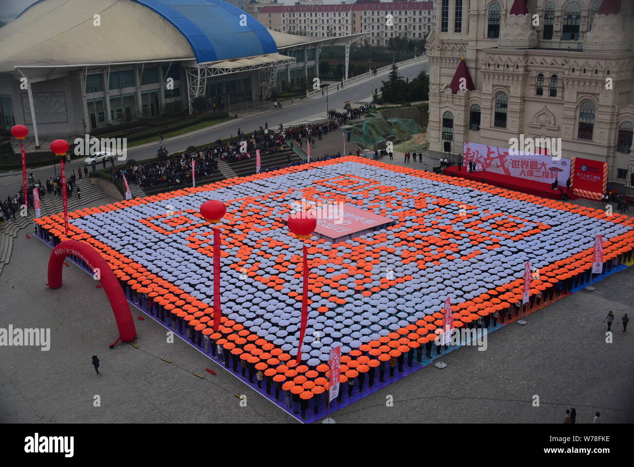Les étudiants titulaires d'parasols line jusqu'à créer le plus grand code QR de l'humain sur la Place Rouge à l'Université de Zhengzhou International Sias Uni Banque D'Images