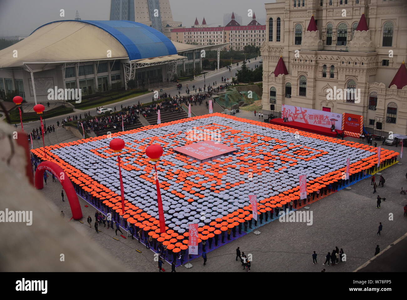 Les étudiants titulaires d'parasols line jusqu'à créer le plus grand code QR de l'humain sur la Place Rouge à l'Université de Zhengzhou International Sias Uni Banque D'Images