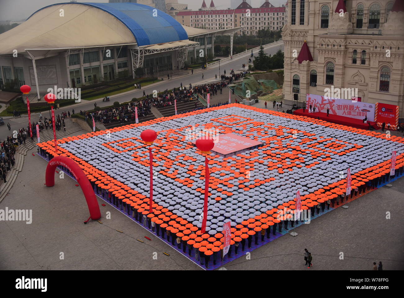 Les étudiants titulaires d'parasols line jusqu'à créer le plus grand code QR de l'humain sur la Place Rouge à l'Université de Zhengzhou International Sias Uni Banque D'Images