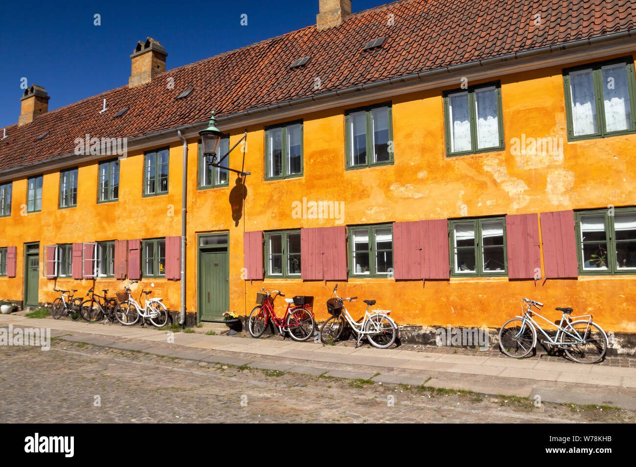 Maisons en rangée historique quartier Nyboder jaune à Copenhague, un ancien quartier de la marine avec des vélos devant les maisons Banque D'Images