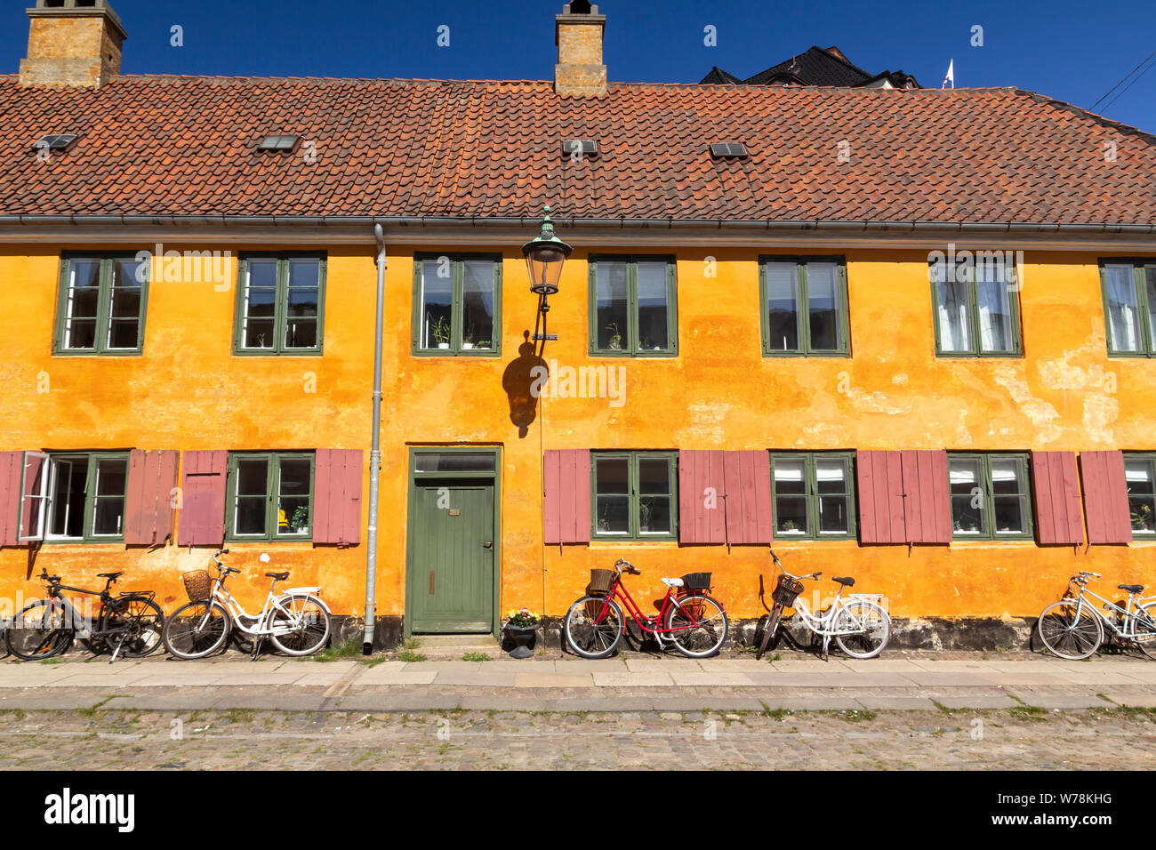 Maisons en rangée historique quartier Nyboder jaune à Copenhague, un ancien quartier de la marine avec des vélos devant les maisons Banque D'Images