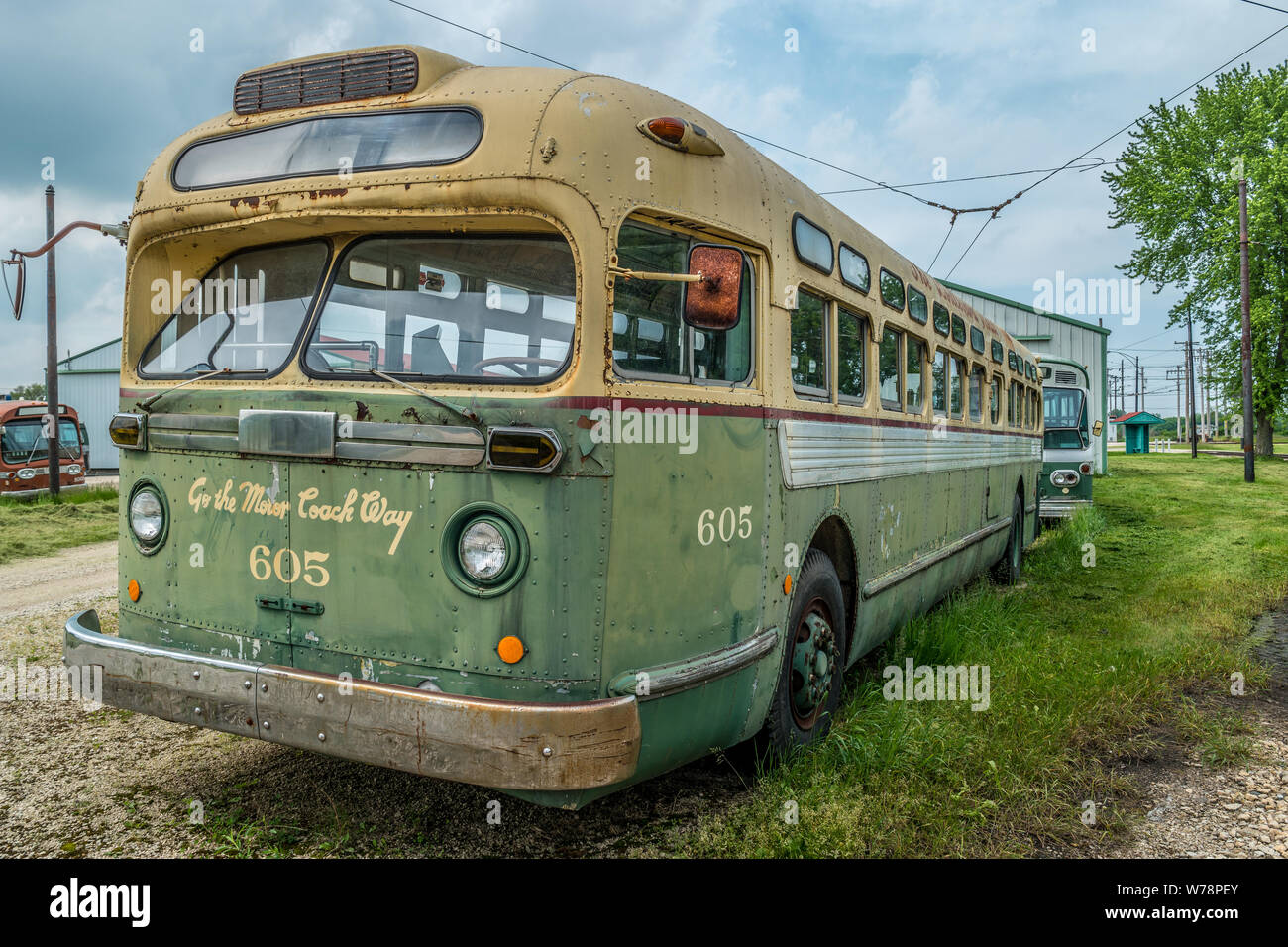 Un bus d'époque close up et un couple d'autres autobus de transport public dans l'arrière-plan abandonné à l'extérieur par une journée nuageuse pour un jour d'attente resto Banque D'Images