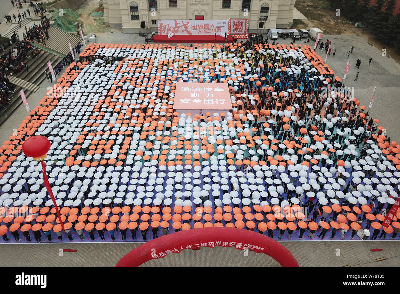 Les étudiants titulaires d'parasols line jusqu'à créer le plus grand code QR de l'humain sur la Place Rouge à l'Université de Zhengzhou International Sias Uni Banque D'Images