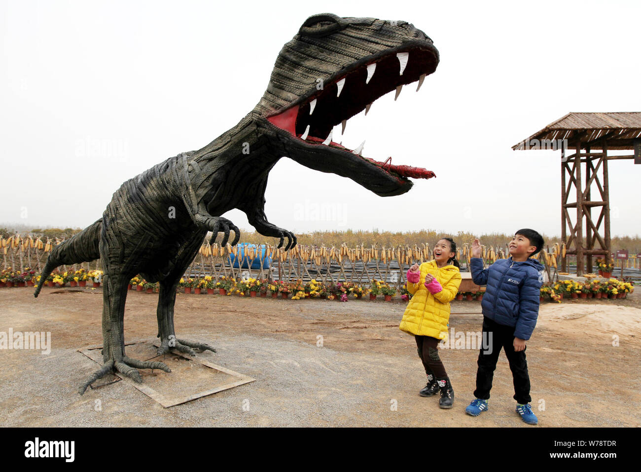Les visiteurs regarder une sculpture des pneus en forme de tyrannosaure à un parc de sculptures des pneus à Zaozhuang City, Shandong province de Chine orientale, le 19 novembre 2017. Banque D'Images