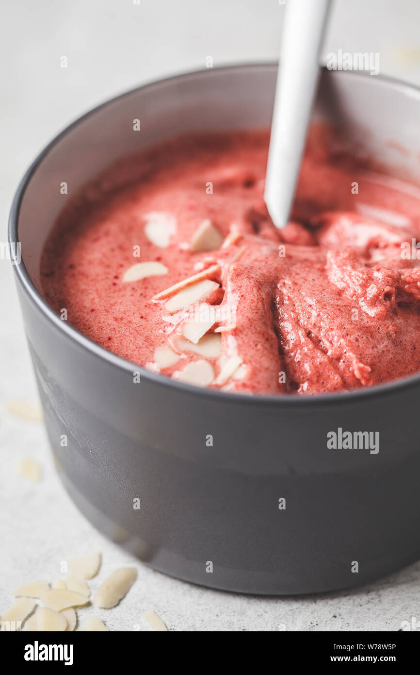 Petit-déjeuner végétalien sain bol. Smoothie cerise baies dans un bol gris. Banque D'Images