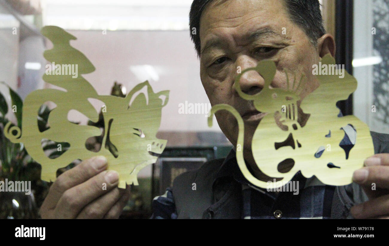 67-year-old man chinois Chongsheng Zhang montre les caractères chinois "Fu", qui signifie bénédiction en anglais, avec les formes des signes du Zodiaque Chinois Banque D'Images