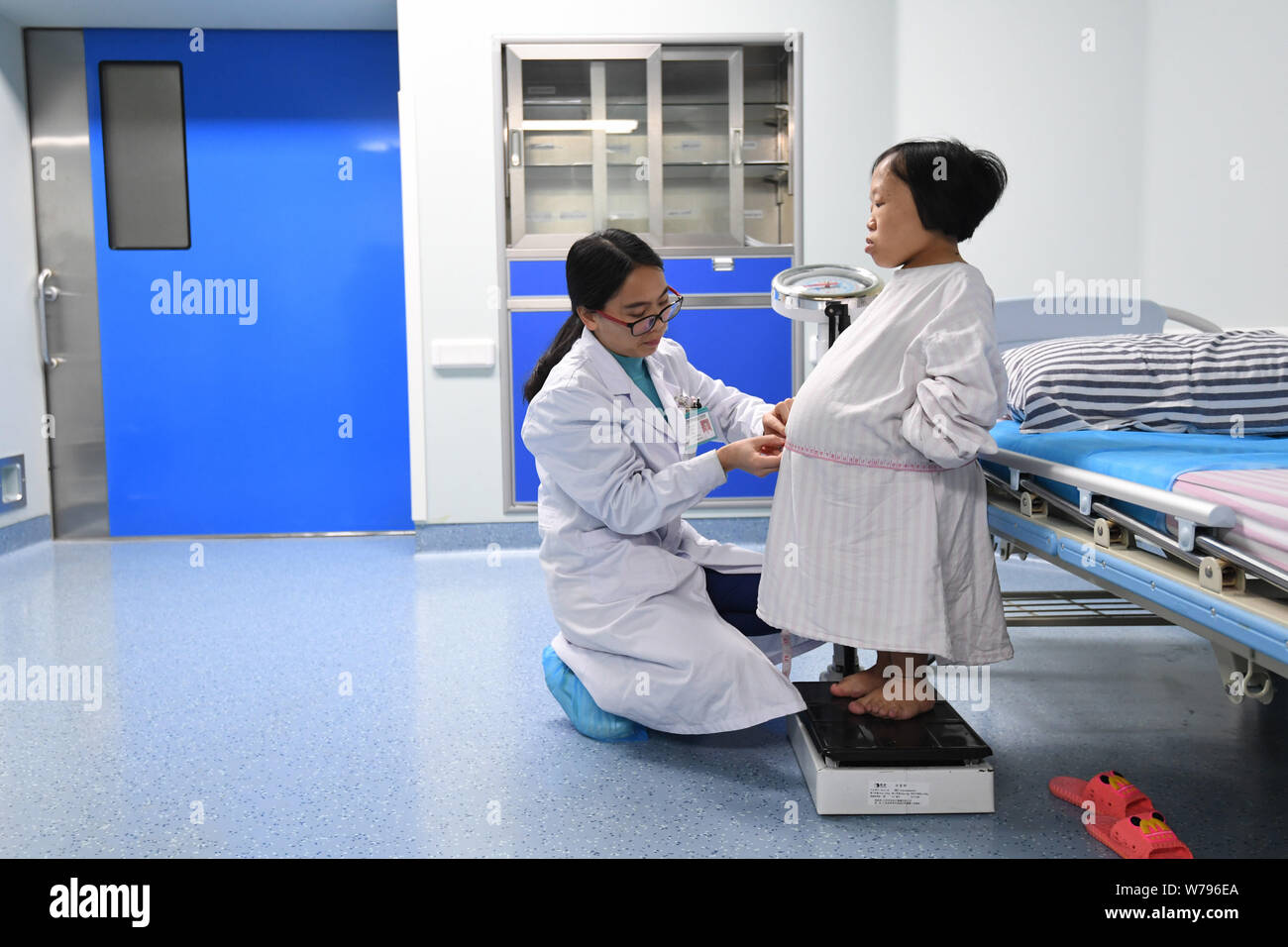 Chinese Woman Hailing Wanda Wei, droite, qui est juste un peu plus de trois pieds de haut avec nanisme est examiné par un médecin avant de donner naissance par césarienne sec Banque D'Images