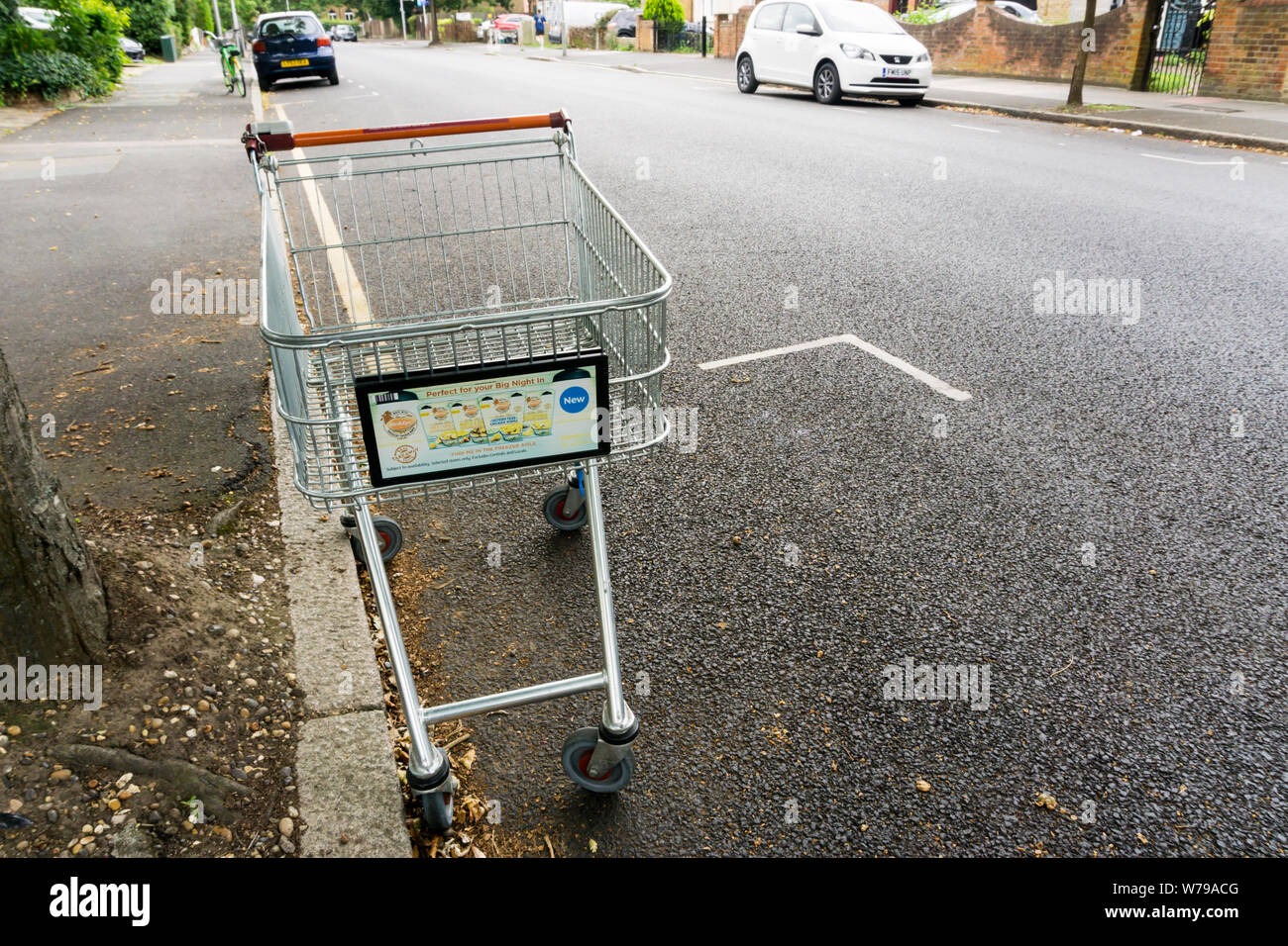 Un chariot de supermarché abandonné dans une rue résidentielle de banlieue. Banque D'Images