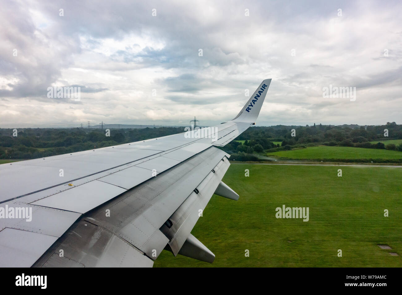 Les volets de l'aile se préparent à ouvrir sur un Boeing 737 de Ryanair - 800 pour un atterrissage sous la pluie sur la piste de l'aéroport de Manchester Banque D'Images