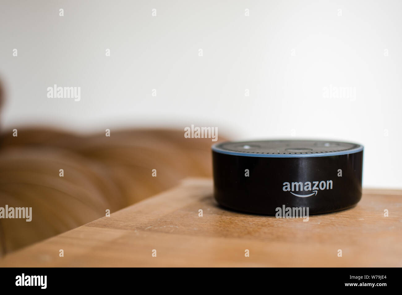 Amazon Alexa Echo point dans la salle de séjour avec un marron canapé en arrière-plan Banque D'Images