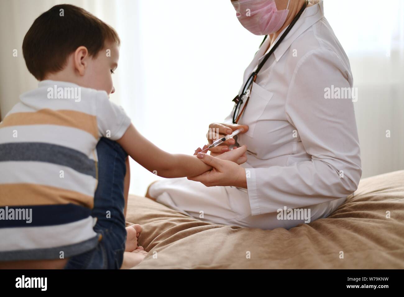 Le processus de réalisation d'un test de Mantoux pour un enfant. Un médecin avec une seringue dans ses mains se trouve en face d'un enfant. Banque D'Images