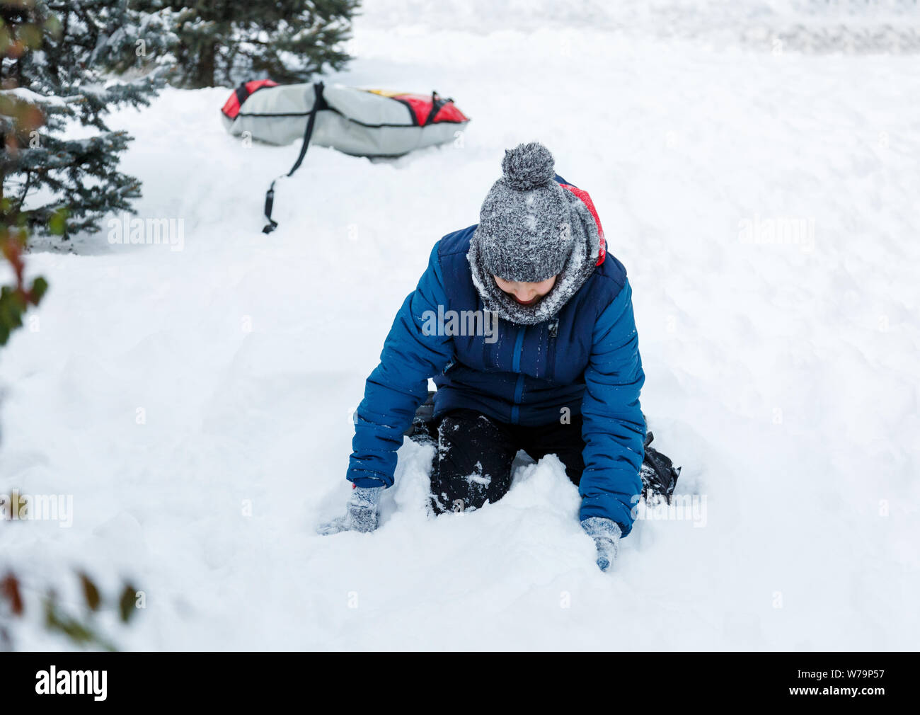 Happy cute excited boy adolescent joue avec la neige, fait boule de neige. Activité d'hiver, des loisirs actifs et de divertissement concept. Banque D'Images