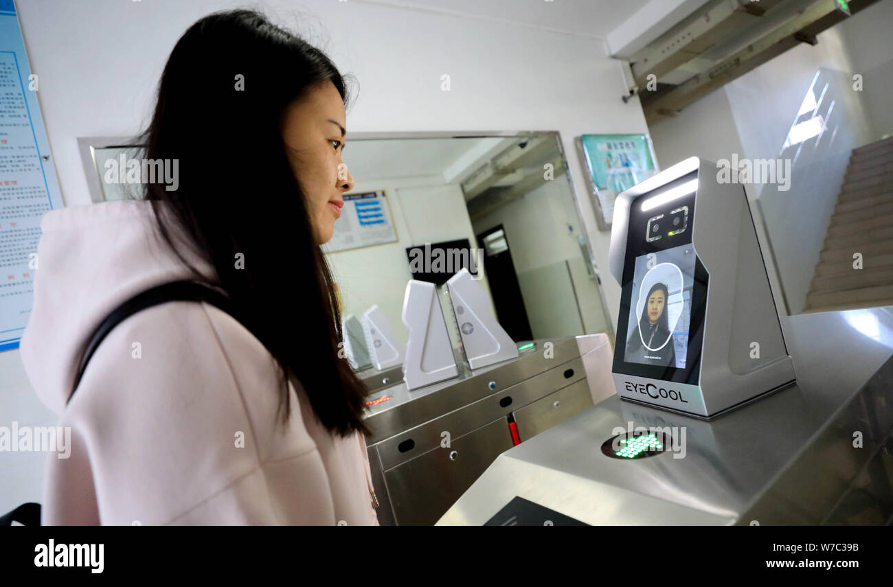 Un étudiant a l'air dans l'appareil d'utiliser des machines de reconnaissance faciale pour entrer dans le dortoir à l'Université de Shandong à Jinan City, Shandong, Chine de l'est p Banque D'Images