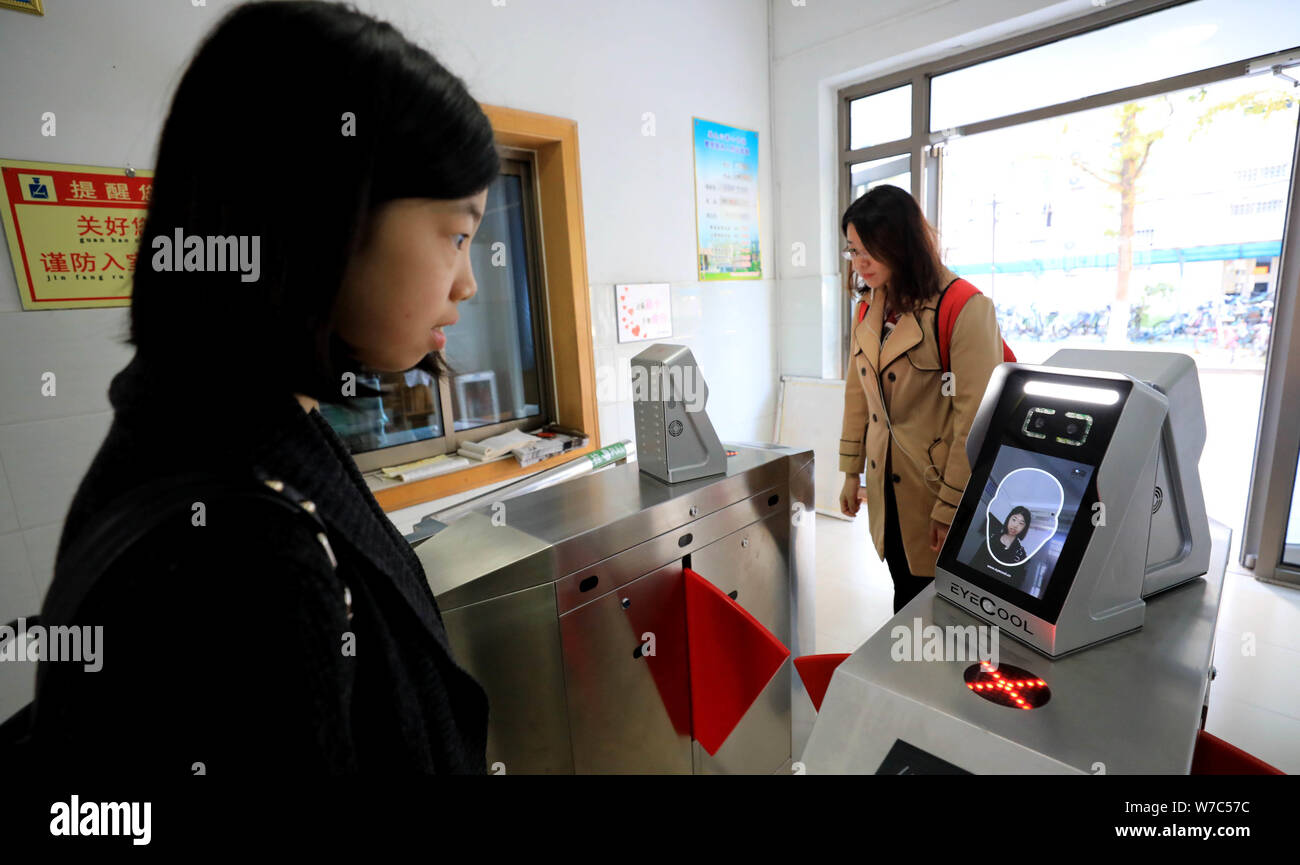 Un étudiant a l'air dans l'appareil d'utiliser des machines de reconnaissance faciale pour entrer dans le dortoir à l'Université de Shandong à Jinan City, Shandong, Chine de l'est p Banque D'Images
