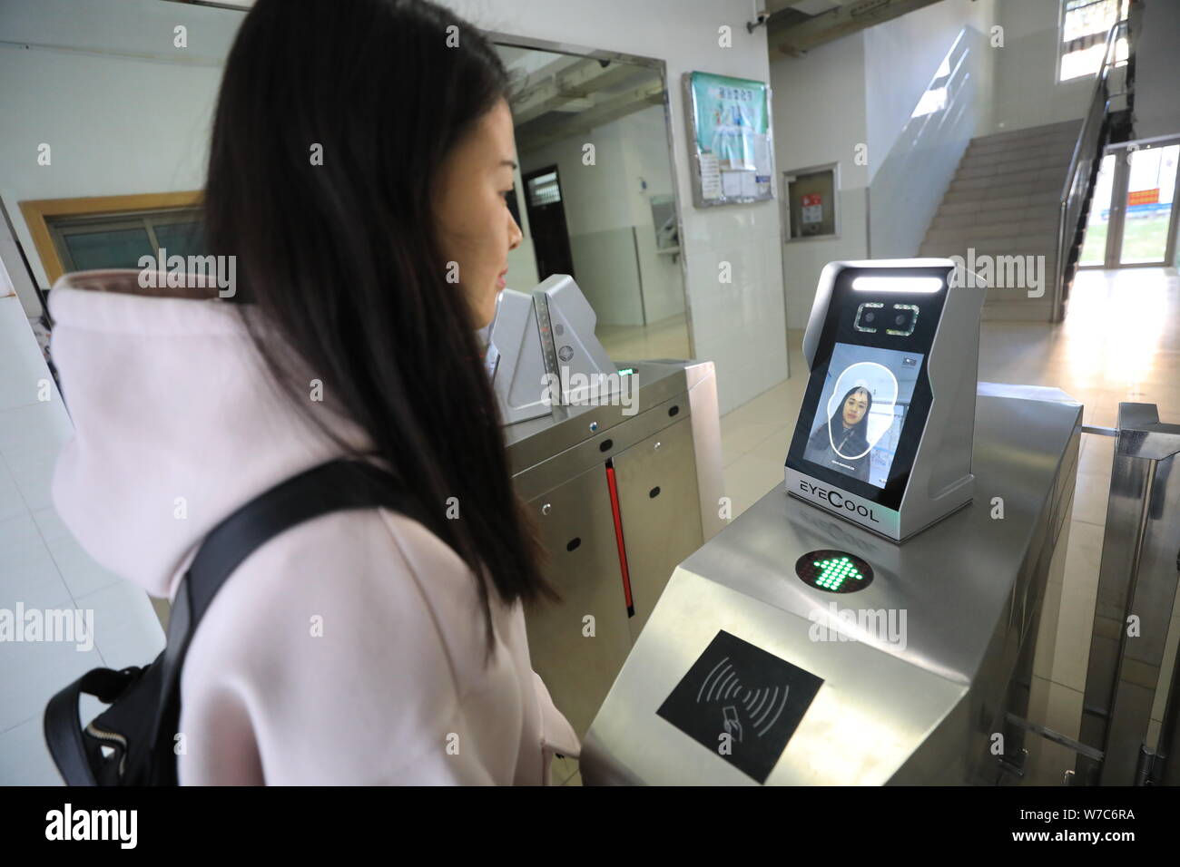 Un étudiant a l'air dans l'appareil d'utiliser des machines de reconnaissance faciale pour entrer dans le dortoir à l'Université de Shandong à Jinan City, Shandong, Chine de l'est p Banque D'Images