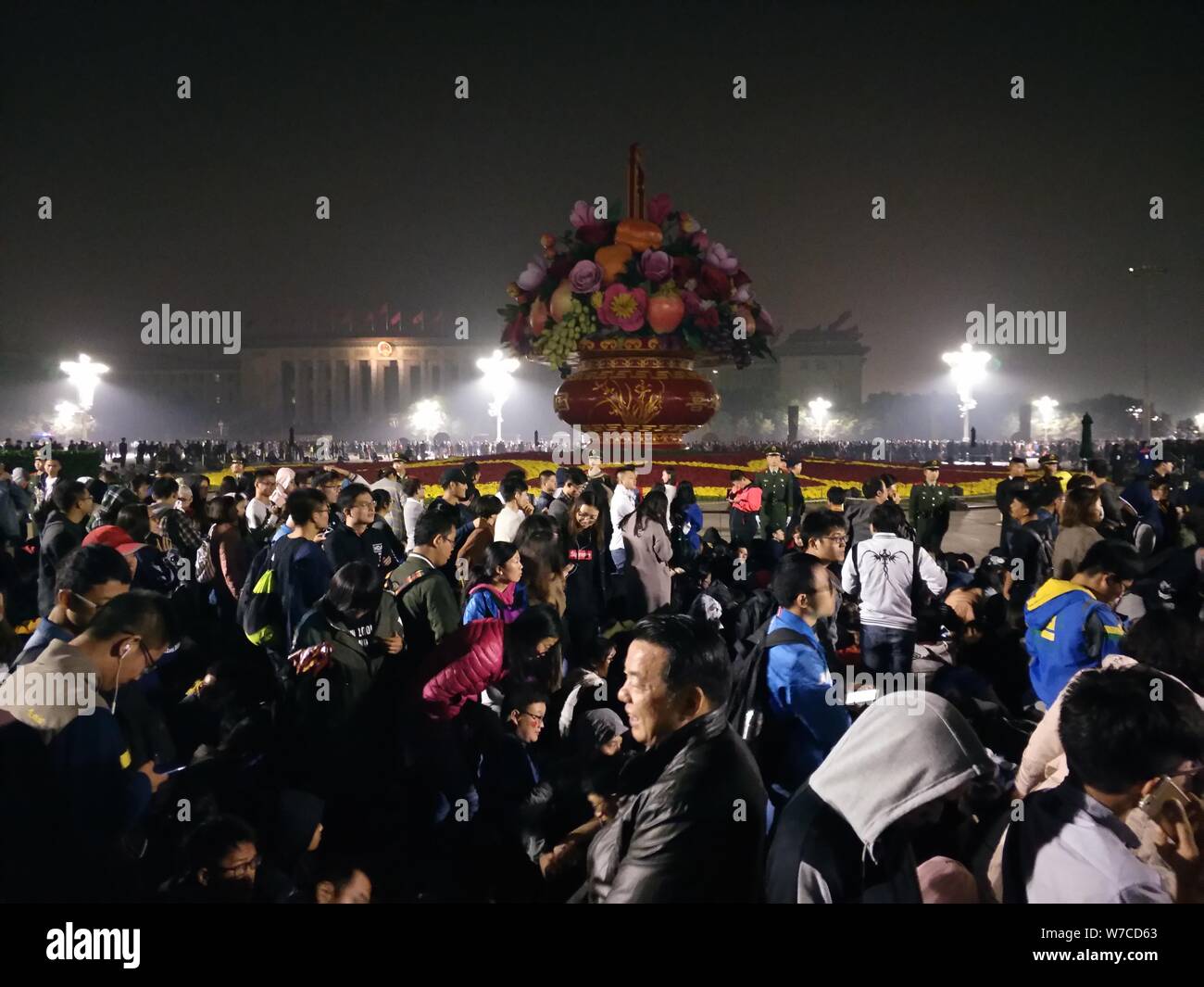 Les gens attendent à la place Tian'anmen pour regarder la cérémonie de levée du drapeau national marquant le 68e anniversaire de la fondation de la République Populaire Banque D'Images